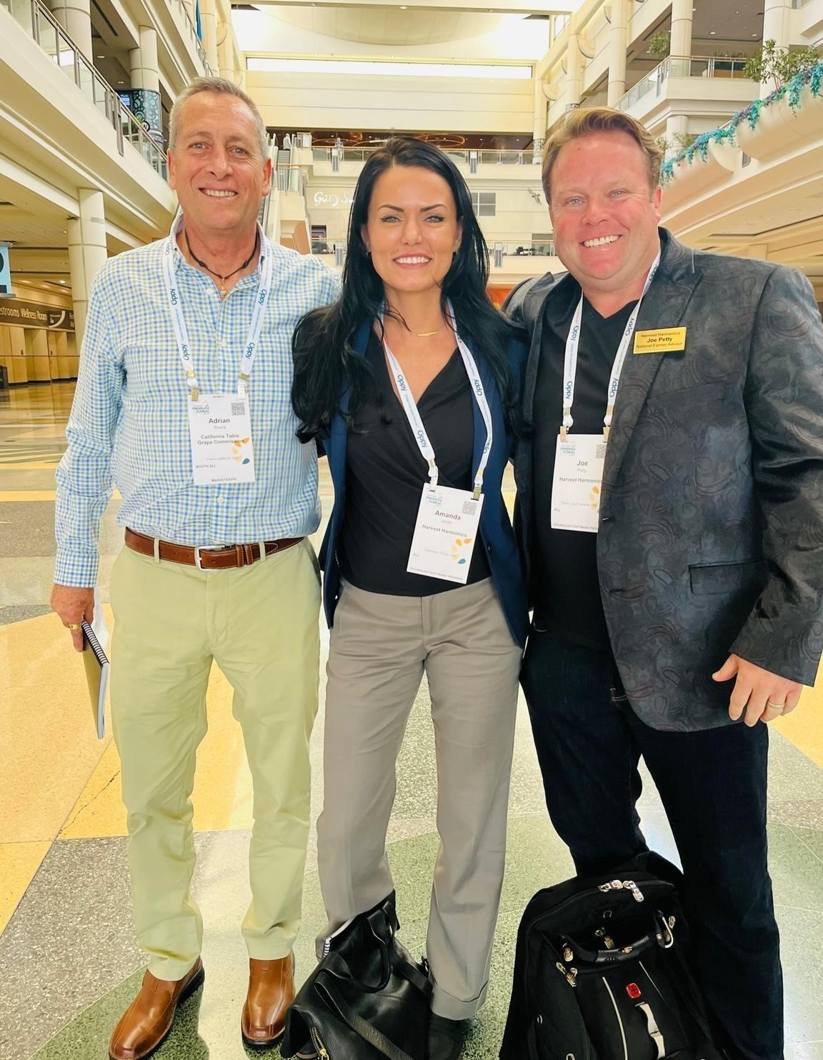 Amanda Smith, Adrian Rivera and Joe Petty standing together at a produce industry convention.